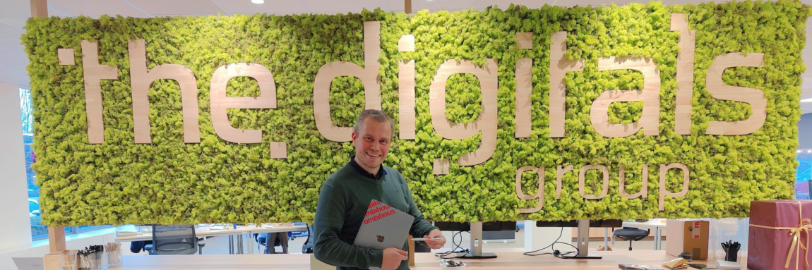 Patrick Van den Broeck, managing director van Ambitious, staat trots voor een groene mosmuur.