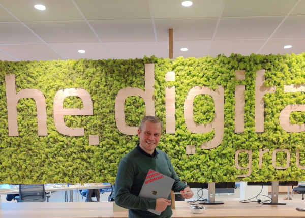 Patrick Van den Broeck, managing director van Ambitious, staat trots voor een groene mosmuur.