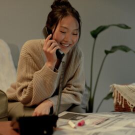 Blije vrouw belt voor een vacature in de krant.